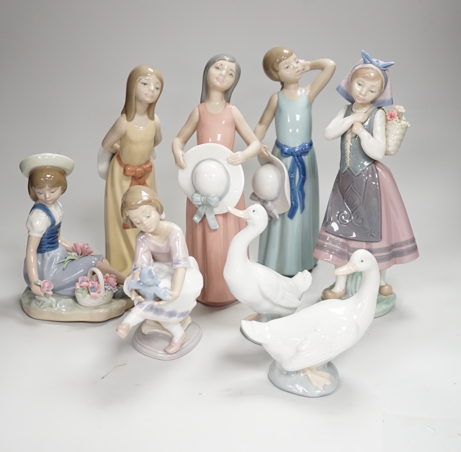 Six Lladro figures of girls, three with hats, one with a Teddy, two peasant girls with flowers and two Nao ducks, the largest 26cm high (8)